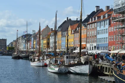 Bunte historische Häuser am Hafen Kopenhagens mit Booten und Wasserspiegelung
