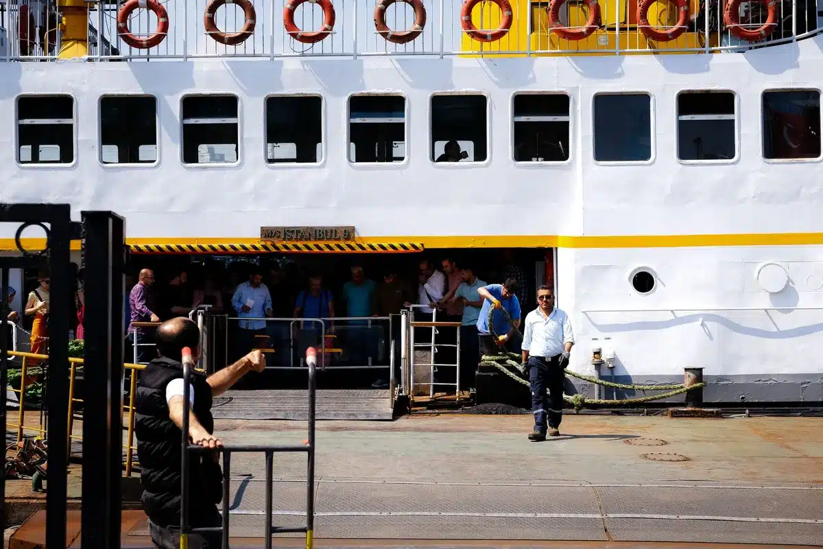 Ein Passagier mit Gepäck verlässt das Kreuzfahrtschiff über die Gangway