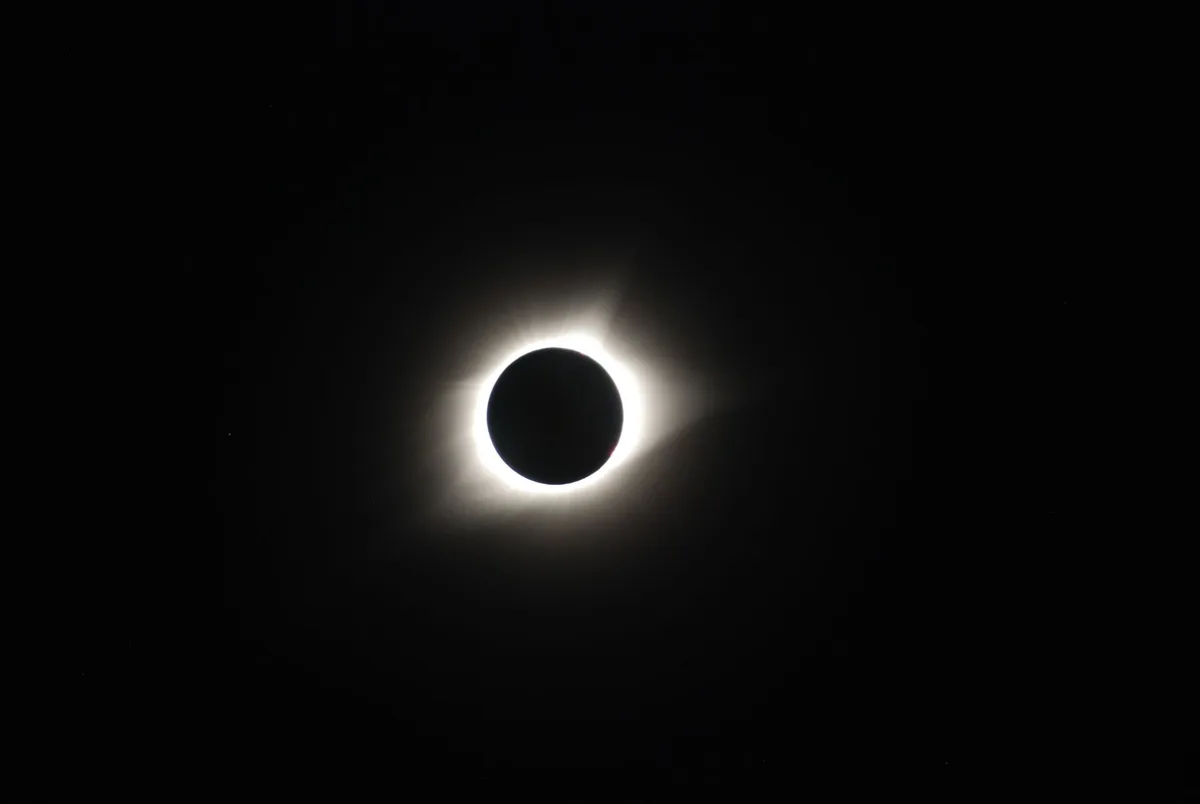 Totale Sonnenfinsternis mit Mond vor der Sonne am dunklen Himmel