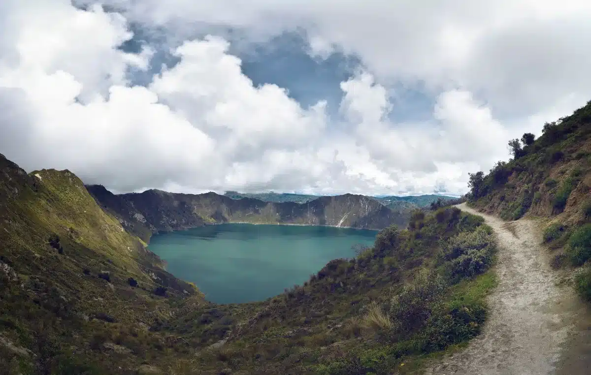 Wanderer auf einem Pfad zum Vulkankrater mit See in der Caldera