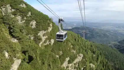 Luftaufnahme eines großen Freizeitparks mit Achterbahnen, Themenbereichen und Besuchern an einem sonnigen Tag