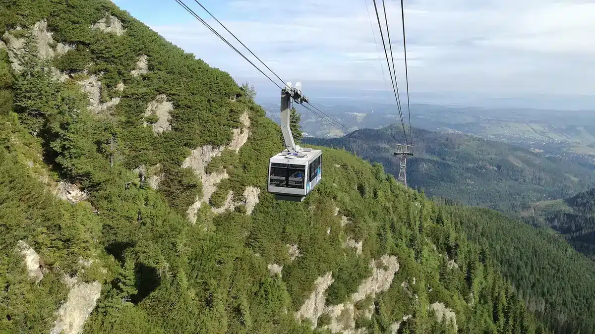 Luftaufnahme eines großen Freizeitparks mit Achterbahnen, Themenbereichen und Besuchern an einem sonnigen Tag