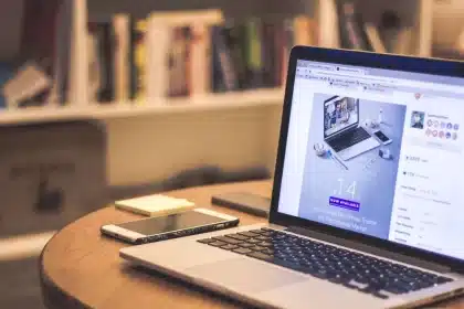 Person working at desk with laptop and research materials, symbolizing journalistic fact-checking