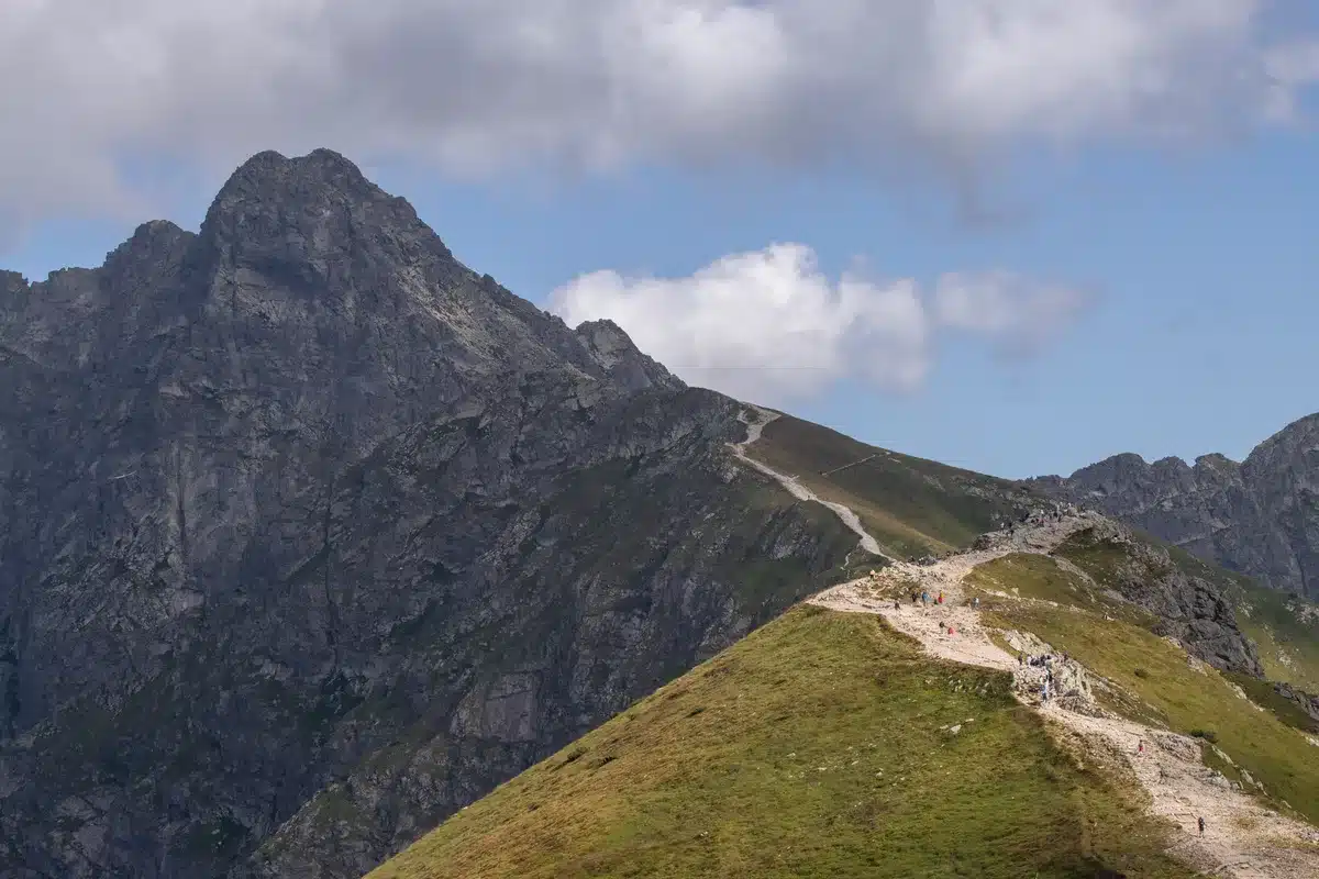 Wanderer auf einem Gebirgspfad mit weiter Aussicht auf eine nordische Berglandschaft