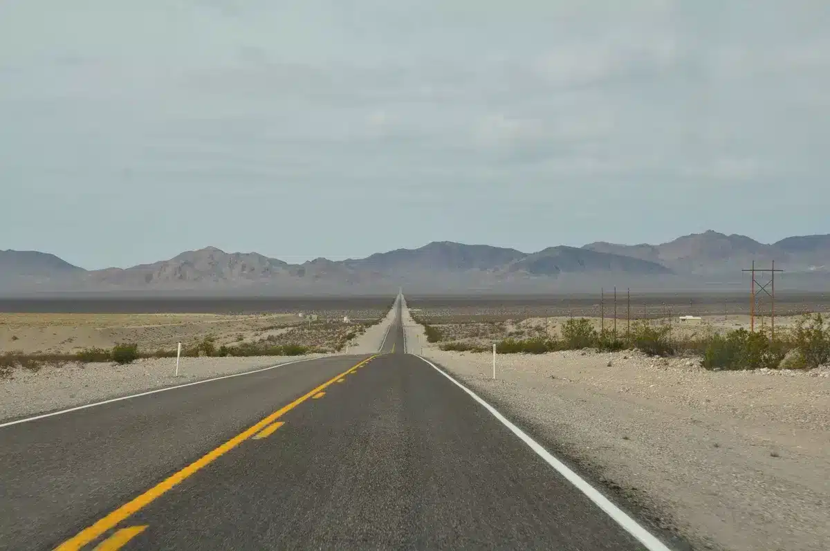 Schnurgerade W&uuml;stenstra&szlig;e, die in den Horizont f&uuml;hrt