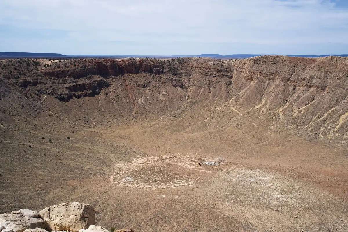 Großer Krater mit steilen Wänden in Wüstenlandschaft