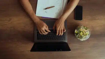 Ein Schreibtisch mit Notizbuch, Stift und Papieren im Licht