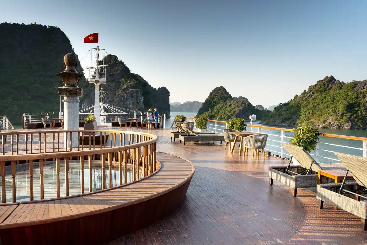 Luxusyacht mit Passagieren auf dem Deck, Blick auf entfernte Küste und kleine Häfen
