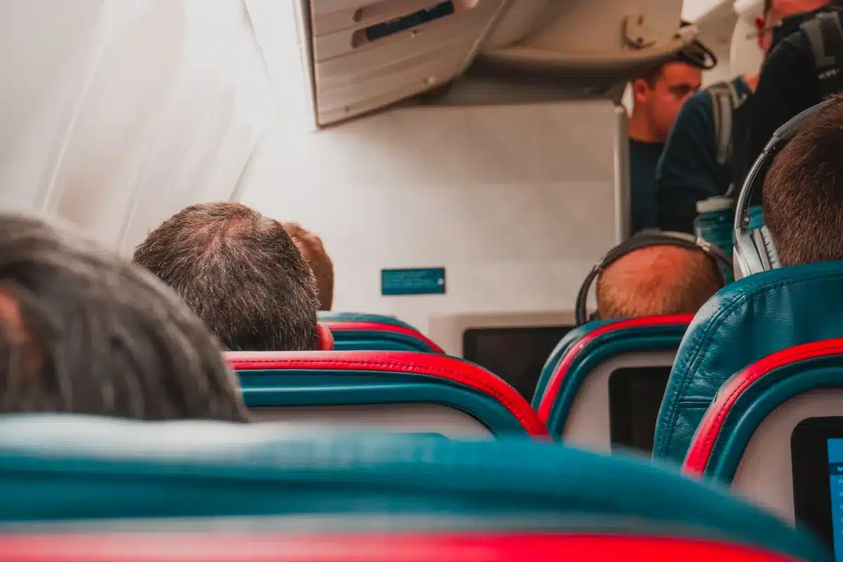 Passagiere laden Geräte während des Fluges auf ihren Sitzen auf