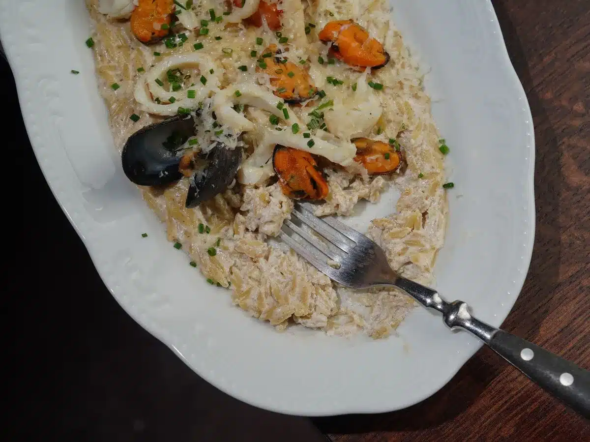 Traditionelle mediterrane Gerichte mit Meeresfrüchten auf einem Tisch im Freien