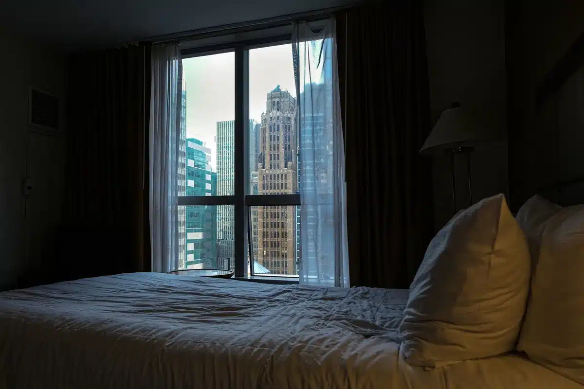 Luxuri&ouml;ses Hotelzimmer mit gro&szlig;z&uuml;gigem Bett und Stadtblick auf Manhattan