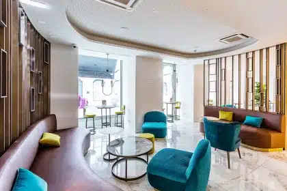 Elegante Hotellobby mit Marmorsäulen, Goldakzenten und modernem Empfangstresen