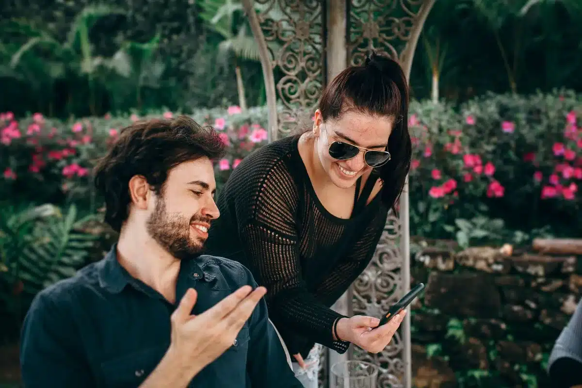 Paar sitzt zusammen und schaut auf Smartphone mit Likes und Kommentaren