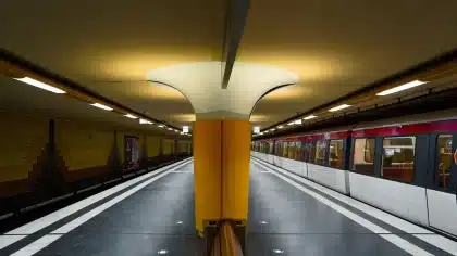 Leere Bahnsteig mit Gleisen und Oberleitung bei Dämmerung