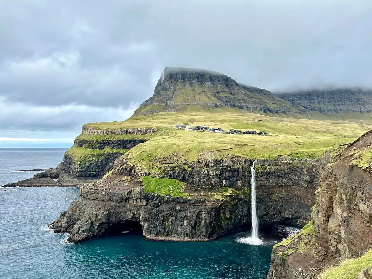 Wasserfall st&uuml;rzt von einer hohen Klippe direkt ins Meer