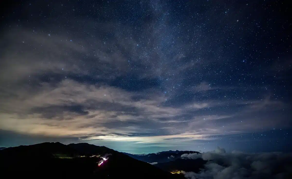 Sternklarer Nachthimmel mit sichtbarer Milchstraße über dunkler Landschaft