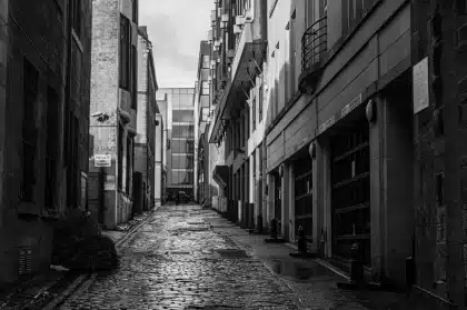 Enge europäische Gasse mit historischen Steinfassaden und Kopfsteinpflaster