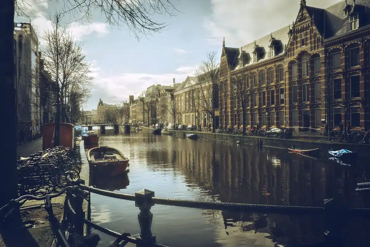 Typische verwinkelte Gasse mit Brücke und geparkten Fahrrädern in Amsterdam