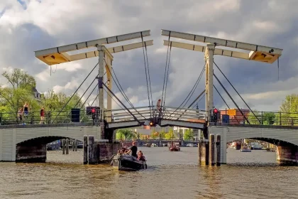 Anonyme Kanalstraße in Amsterdam mit Fahrrädern an einer Brücke und Straßencafés