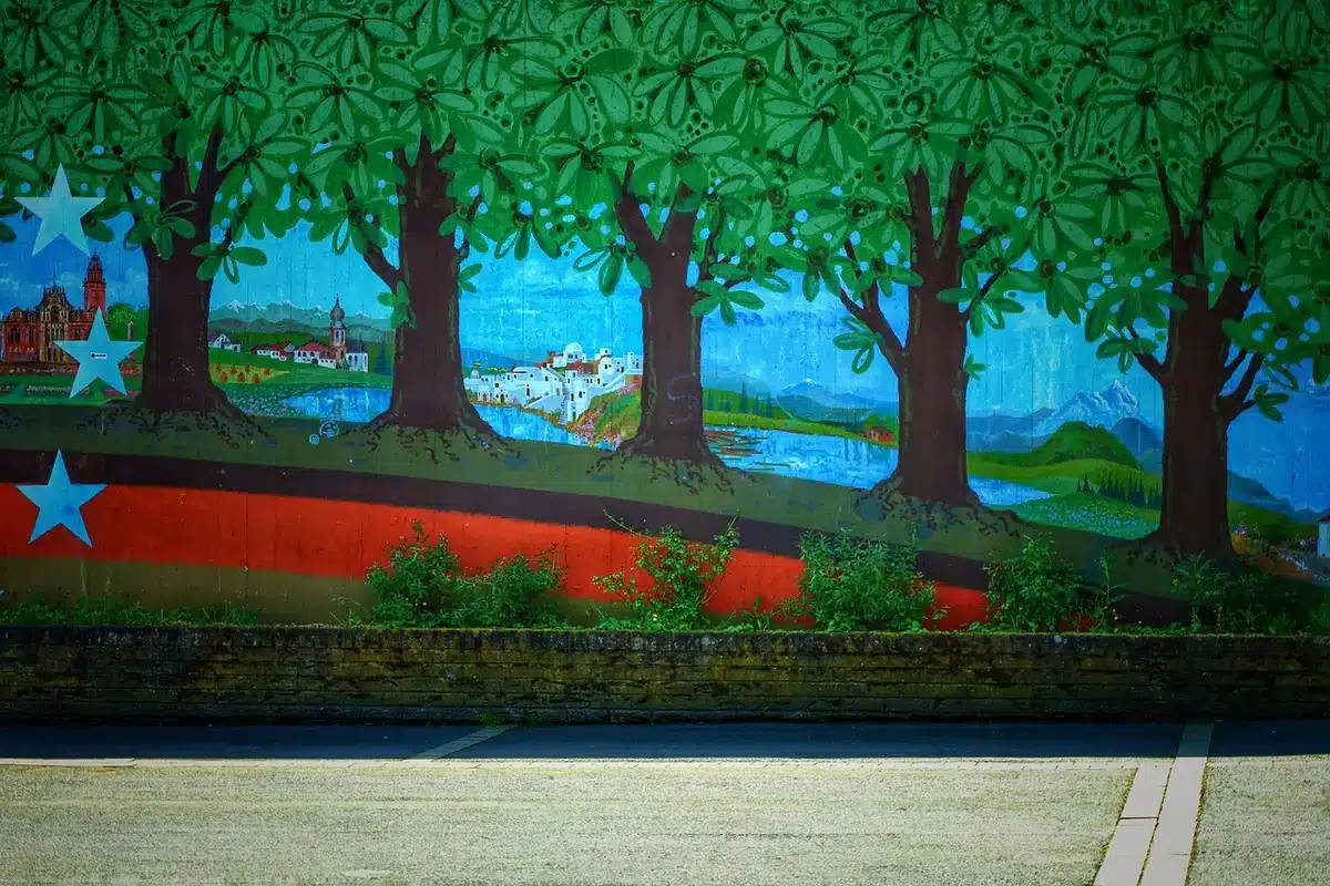 Großes Wandbild an einer Hausfassade mit Künstlern in der Nähe