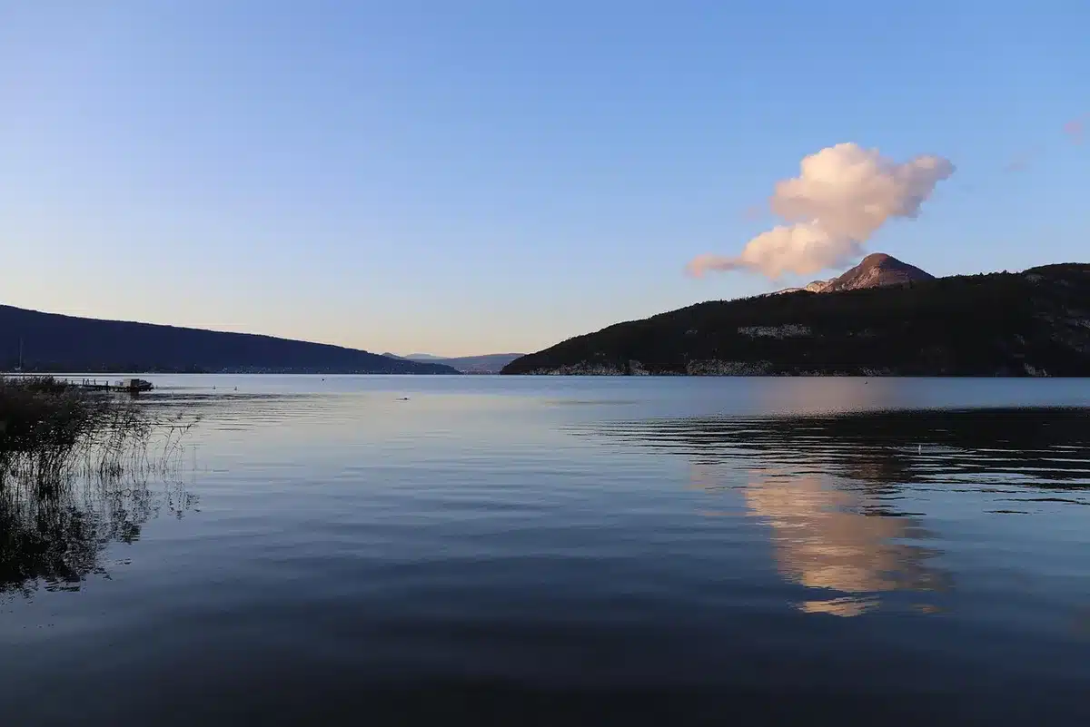 Blick auf den klaren See von Annecy mit Bergen im Hintergrund