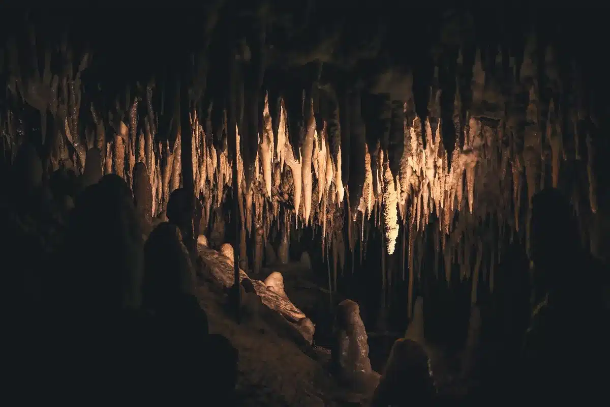 Blick in eine Tropfsteinhöhle mit Stalagmiten und Wegen