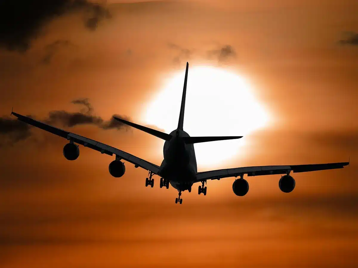Reisende mit Koffer und Einkaufstüten an einem Flughafen-Schalter