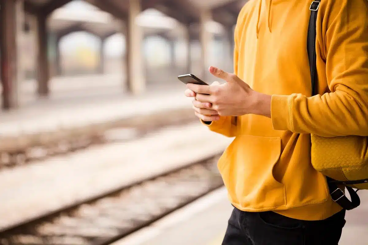 Hände von anonymen Pendlern am Tisch eines Regionalzugs mit Fahrplan und Kaffee