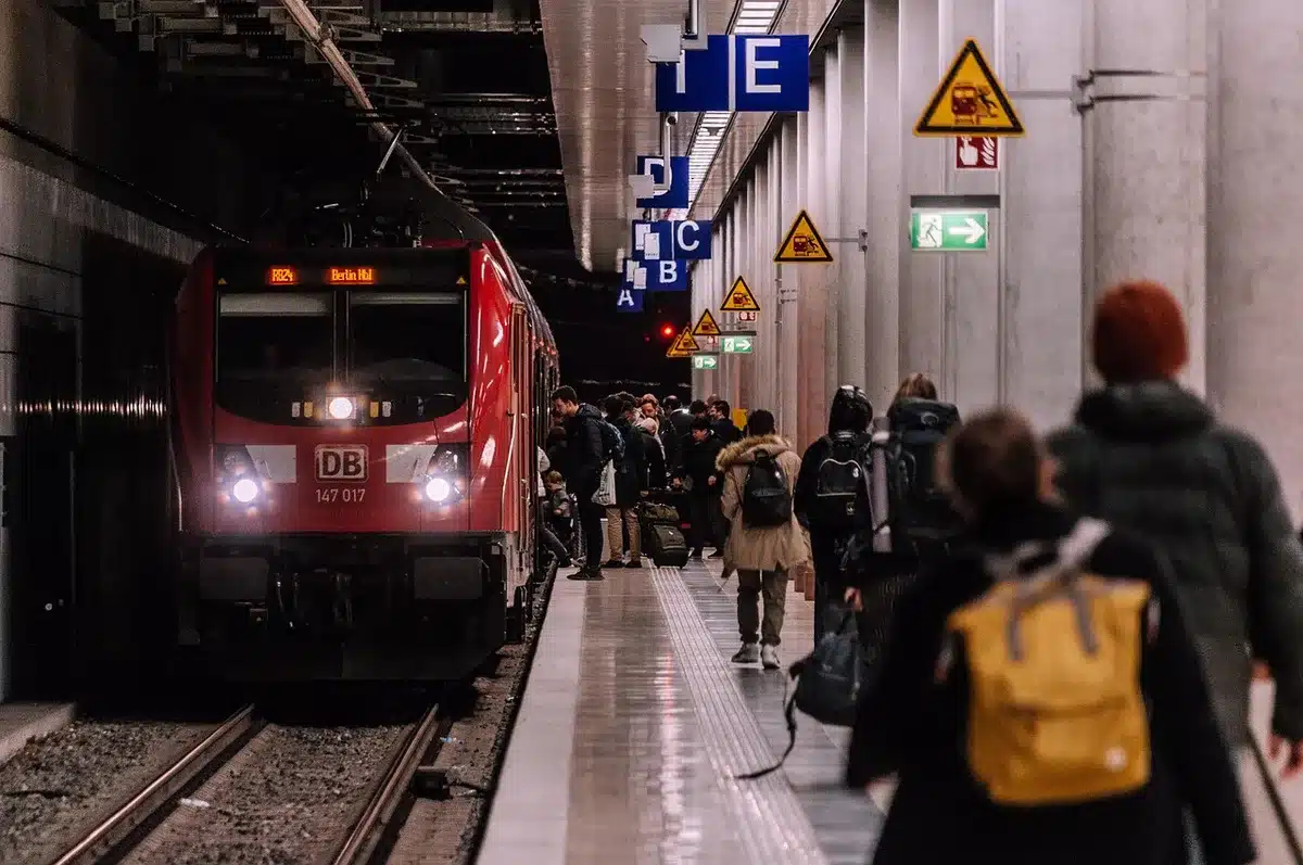 Nachtzug auf Gleis mit digitaler Abfahrtsanzeige im Hintergrund