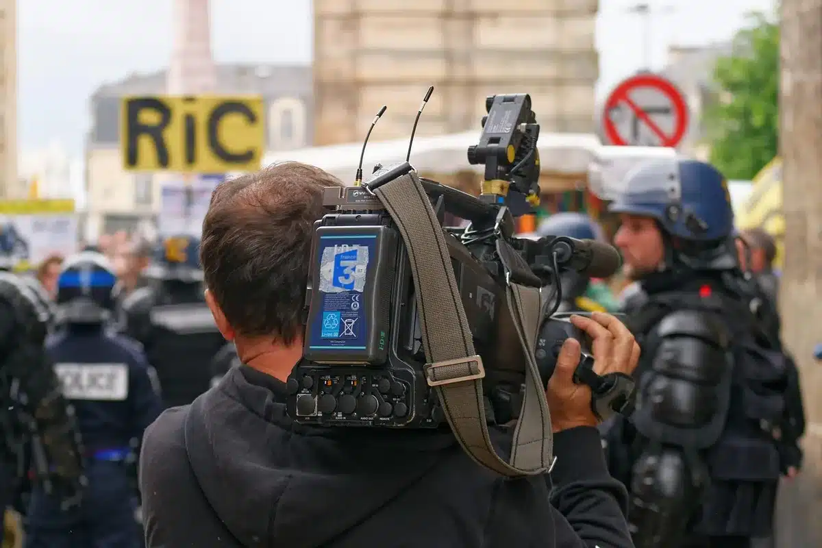 Journalistin prüft Quellen am Schreibtisch mit Laptop und Ordnern