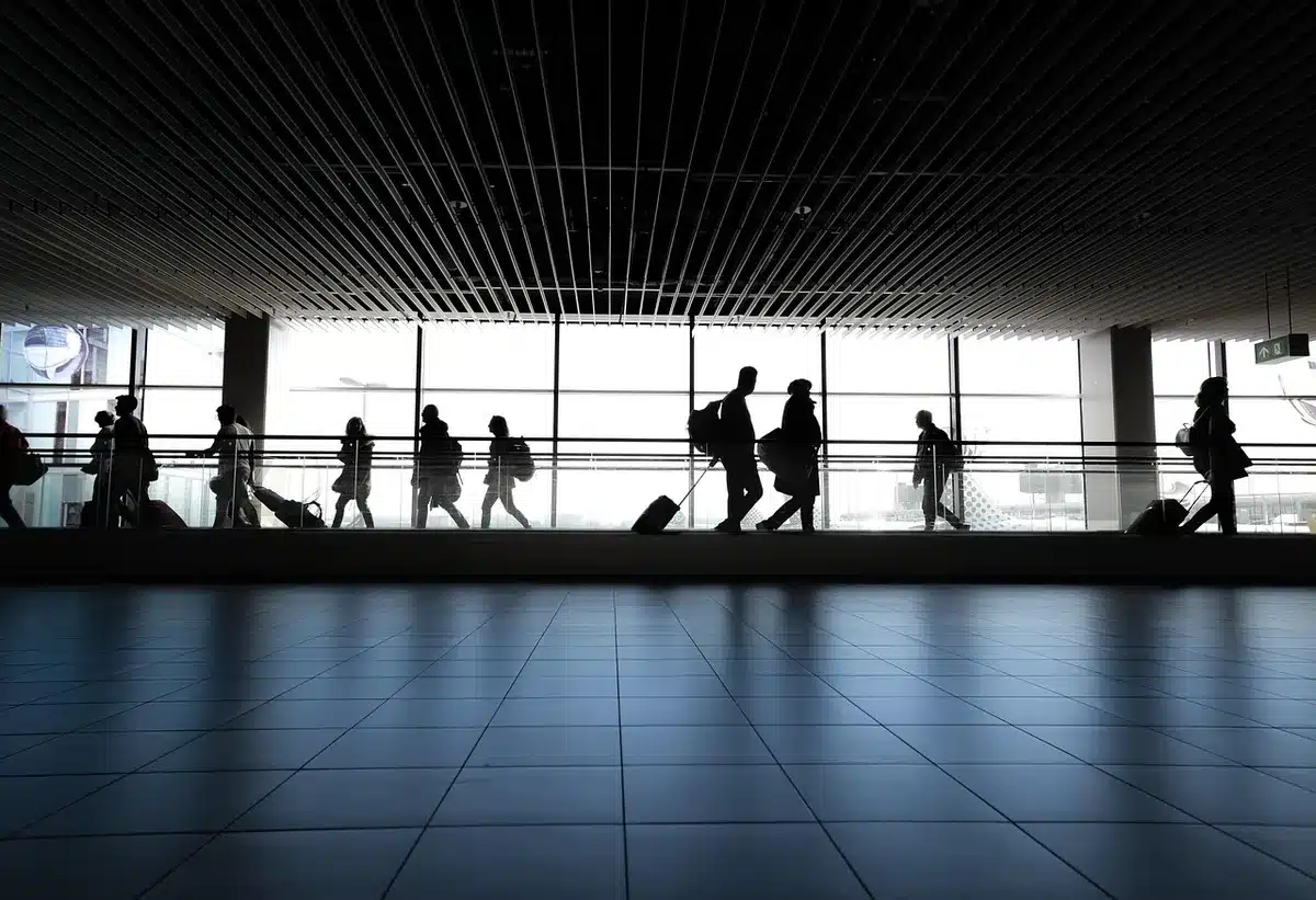 &Uuml;berf&uuml;llter Flughafen-Terminal mit langen Warteschlangen und vielen Passagieren