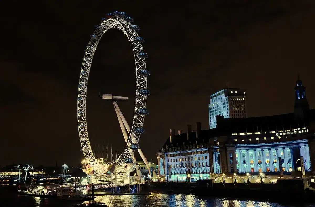 Menschen am Themseufer schauen auf Feuerwerk und die Silhouette von London
