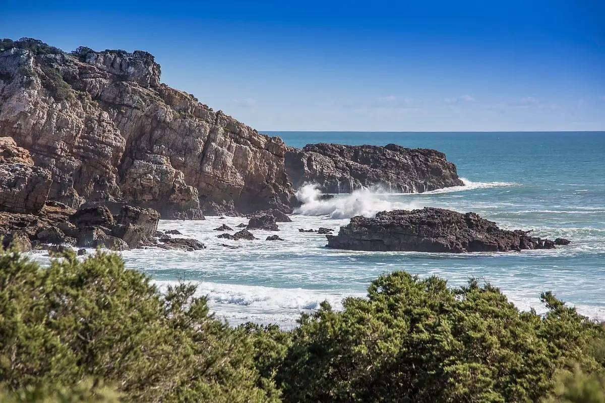 Rote Klippen und türkisfarbene Bucht an der Algarve