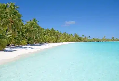 Anonymer Strand mit Promenade, Sand und silhouettierten Spaziergängern an der Küste