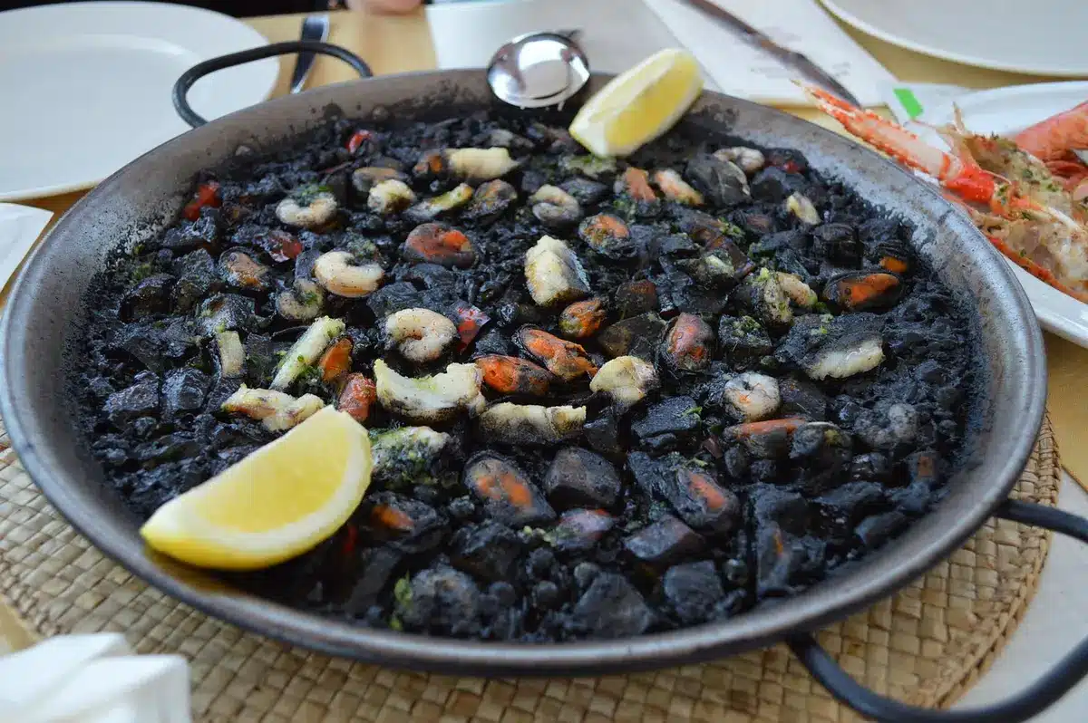 Traditionelle Paella Valenciana in großer Pfanne serviert