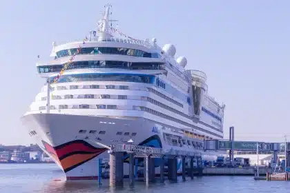 Kreuzfahrtschiff verlässt den Hafen mit Passagieren und Besatzung auf den Außendecks beim Auslaufen