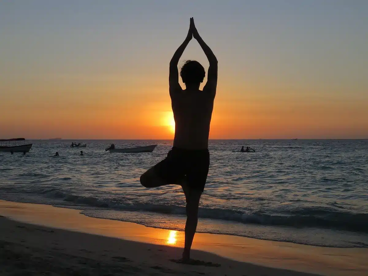 Gruppe von Menschen beim Yoga und Ecstatic Dance in einem hellen Wellness-Studio bei Sonnenaufgang