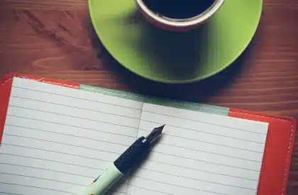 Silhouette einer Person am Schreibtisch mit Laptop und Matcha‑Tasse