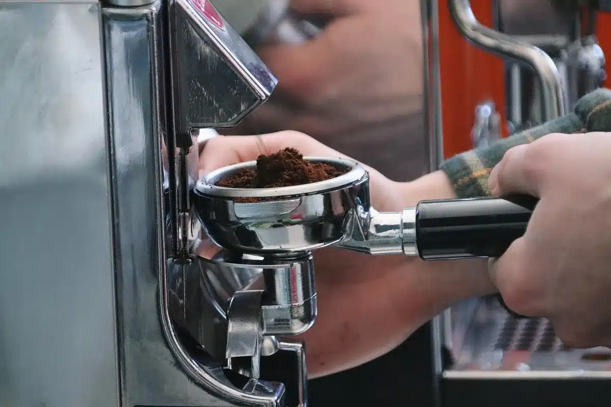 Barista bei der Zubereitung von Kaffee und ein Koch bei Fleischzubereitung an Bord
