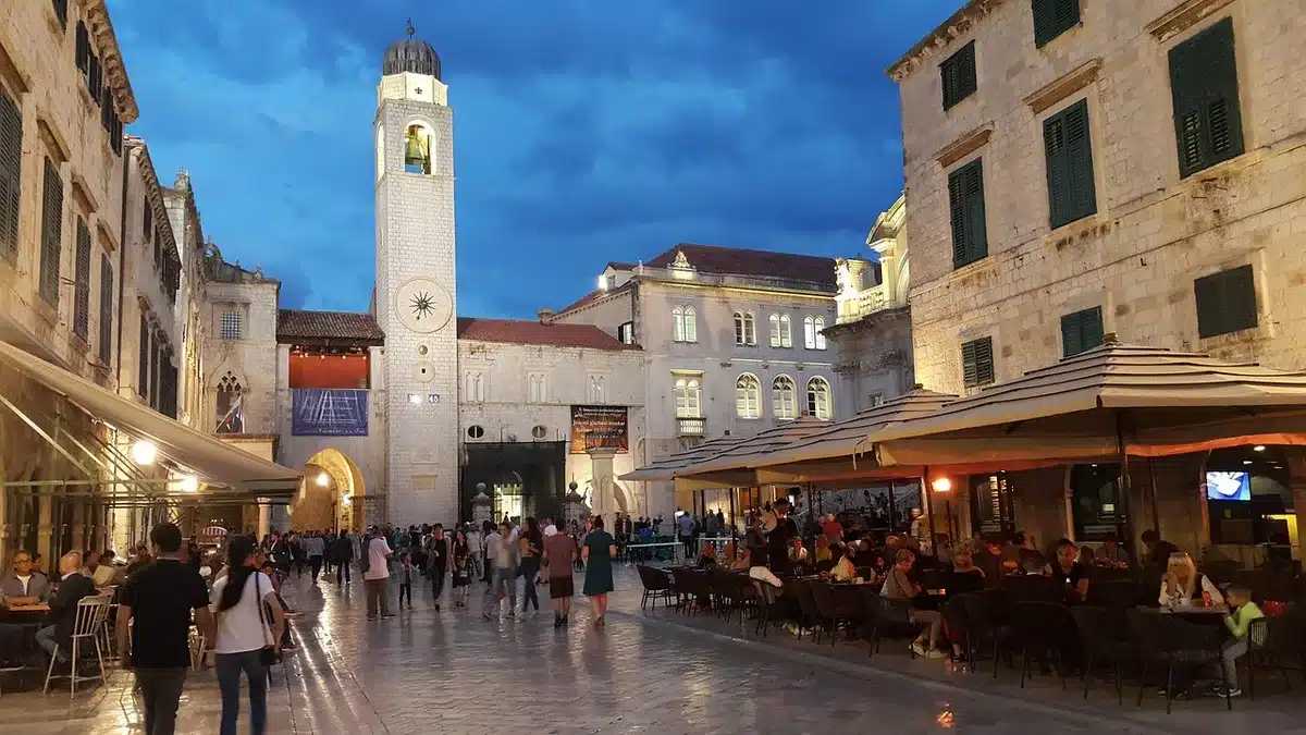Blick auf eine historische Küstenpromenade mit Altstadtmauern und Strand