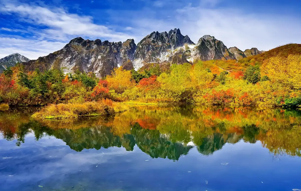 Herbstliche Laubwälder spiegeln sich im klaren Wasser des Sees