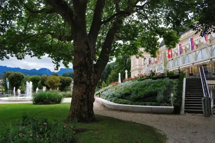 Parkähnlicher Hotelgarten mit See, Terrassen und Fahrrädern am Weg