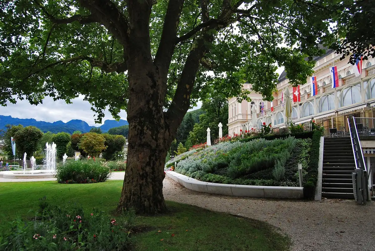 Parkähnlicher Hotelgarten mit See, Terrassen und Fahrrädern am Weg