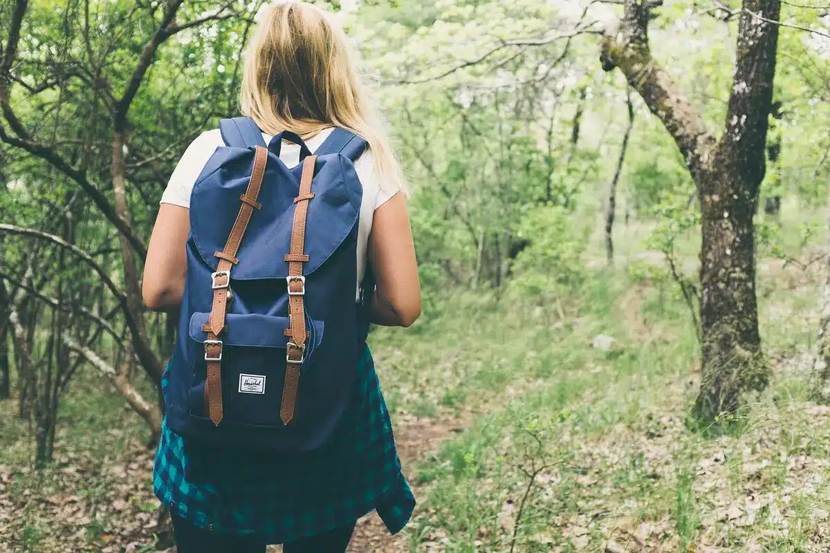 Rucksack und Notizen mit Visumsregeln für Working-Holiday-Aufenthalt