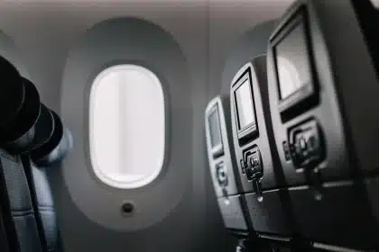 Flugzeugkabine mit Brandschutztasche und anonymen Händen der Crew nahe einem Akku