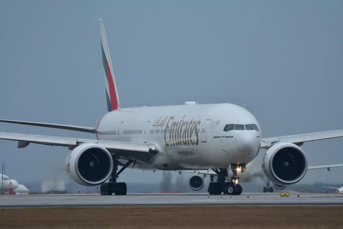 Fluggast geht durch Terminal mit Schildern zu Anschlussflügen