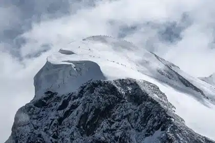 Wanderer vor einem zurückweichenden Gletscher in einem alpinen Tal