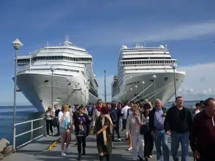 Anonymer Reisender mit Gepäck und Modellschiff in heller Terminalhalle
