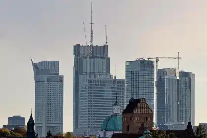 Silhouette eines verjüngenden Turmmodells neben Kranausschnitten vor klarem Himmel