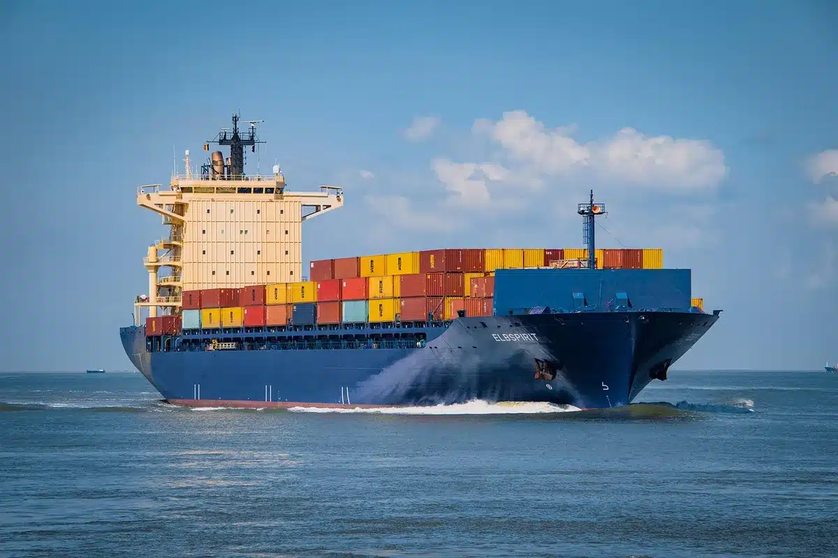 Symbolischer Händedruck vor Modell eines Kreuzfahrtschiffs